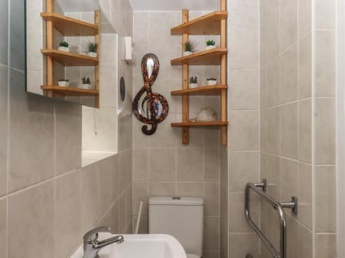 a bathroom with a toilet and a sink and shelves at The Old Telephone Exchange in Exeter