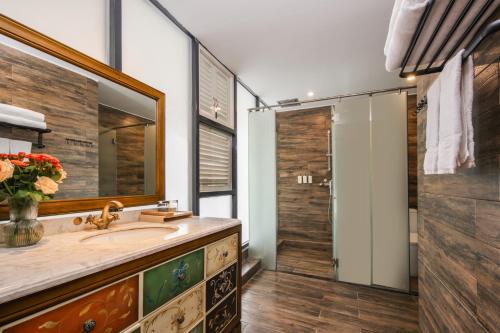 a bathroom with a sink and a mirror and a shower at Meadowscape Resort at Yulong River - Karst Views & Infinity Pool & Tickets Reservation Service & Free Laundry in Yangshuo