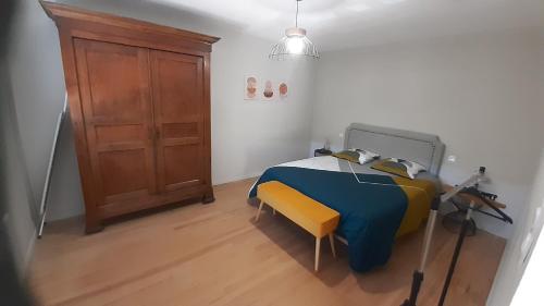 a bedroom with a blue and yellow bed and a wooden door at Maison de campagne in La Fouillade