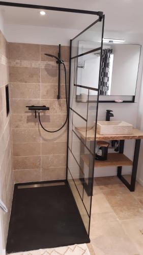 a shower with a glass door in a bathroom at Maison de campagne in La Fouillade
