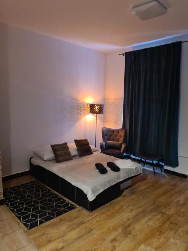 a bedroom with a large bed and a chair at Zakątek Spokoju in Toruń