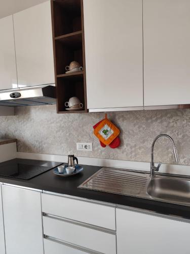 a kitchen counter with white cabinets and a sink at MR1 House Gallipoli in Gallipoli