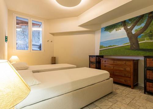 two beds in a bedroom with a painting on the wall at Villa Ritter Orizzonte in Cavoli