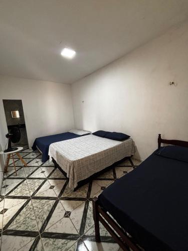 a bedroom with two beds and a tiled floor at Casa em Jacumã in Conde