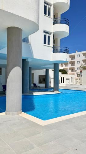 a building with a swimming pool in front of a building at The Navigator - Ocean Heights in Olhos de Água