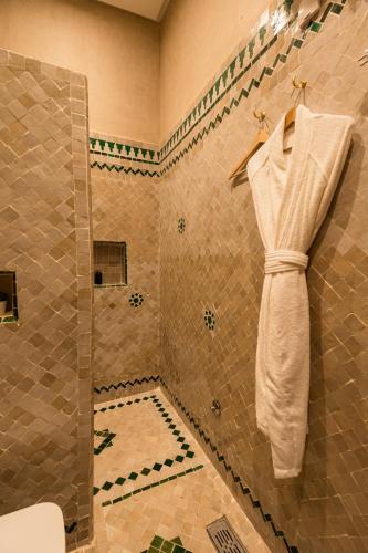 a bathroom with a shower with a towel hanging on the wall at Riad Golden in Rabat