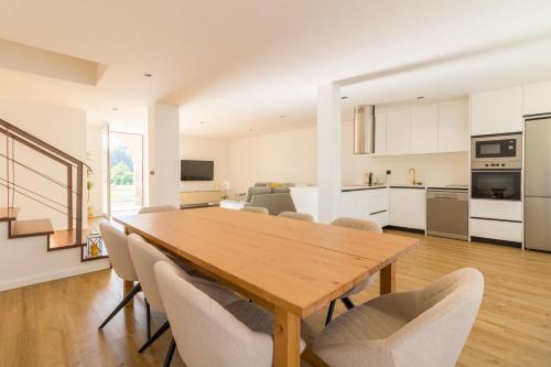 a kitchen and dining room with a wooden table and chairs at Solar dos Arcos • Luxury Rural Retreat & Heated Po