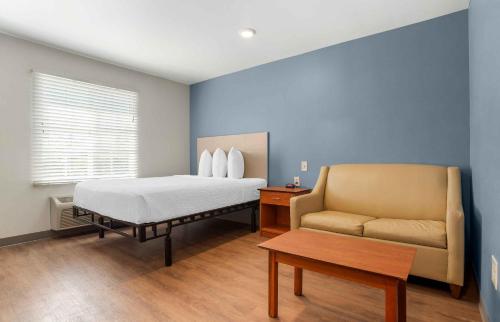 a bedroom with a bed and a couch and a table at Extended Stay America Select Suites - Atlanta - Chamblee in Atlanta