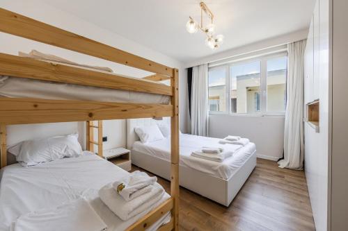 a bedroom with two bunk beds and a window at Talea Elegant Escape by PikHost in Lezhë