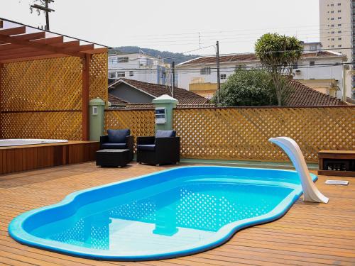 a swimming pool on the deck of a house at Pousada Nosso Lar - Opte sem ou com Café, Estacionamento e a uma Quadra da Praia in Guarujá