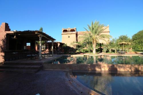 a swimming pool at a resort with a building in the background at La Kasbah d'Ouzoud in Ouzoud