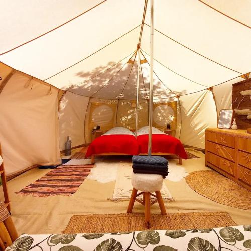 a bedroom with a bed in a tent at Bus magique avec tente glamping in Saint-Palais