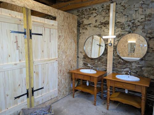 a bathroom with two sinks and two mirrors at Bus magique avec tente glamping in Saint-Palais
