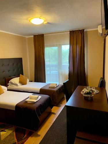 a hotel room with two beds and a table at Hanul Lui Bogdan Economy INN in Făget