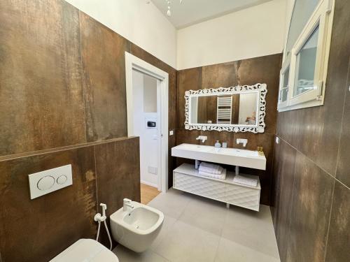 a bathroom with a sink and a toilet and a mirror at Santa Caterina 1604 Suites in Anzola dell'Emilia