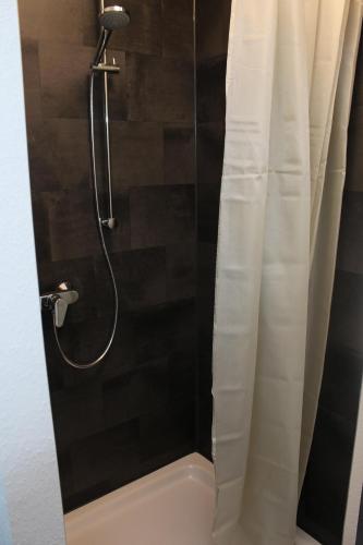 a bathroom with a shower with a shower curtain at Bismarck Hostel Öhringen in Öhringen
