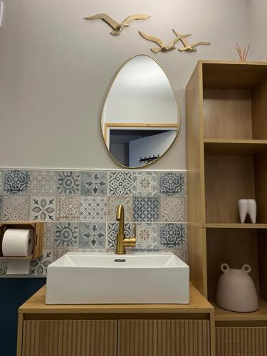 a bathroom with a sink and a mirror at Au rythme de Plume et Louna in Molompize