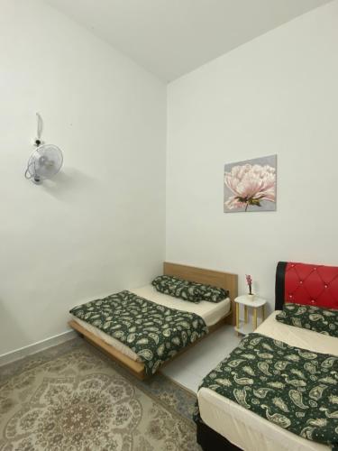 a room with two beds and a rug at Rumah Homestay in Kangar