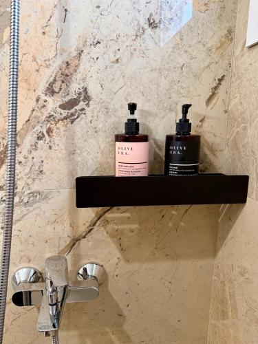a bathroom with two bottles of soap on a shelf at LIV Aspropyrgos in Asprópirgos