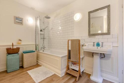 a bathroom with a sink and a bath tub and a mirror at Character cottage with garden - Central Buxton in Buxton