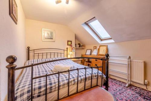 a bedroom with a bed and a skylight at Character cottage with garden - Central Buxton in Buxton