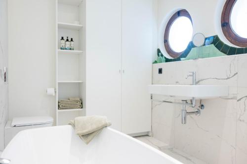 a white bathroom with a sink and a mirror at Nova Zembla in Mechelen