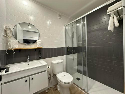 a bathroom with a toilet and a sink and a shower at Hotel Cavaleiros De Cristo in Tomar