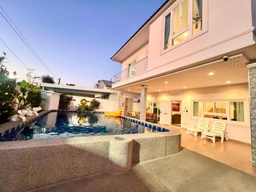a house with a swimming pool in front of a house at Relax Pool Villa Near Walking Street,jacuzzi ,BBQ 5Bed 6Bath City house54 in Pattaya South