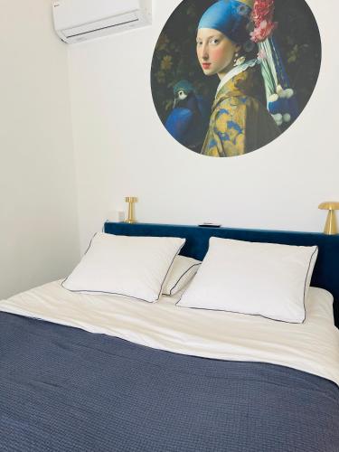 a bedroom with a bed with a painting of a woman at Dushi Blou, private monumentje in Otrabanda in Willemstad