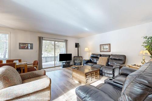 a living room with leather furniture and a television at Dog-Friendly Sunriver condo with deck bikes in Sunriver