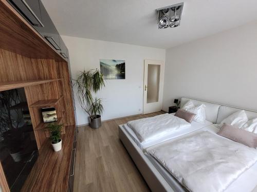 a white bedroom with a large white bed in it at Ferienwohnung Birkenhügel in Schörfling