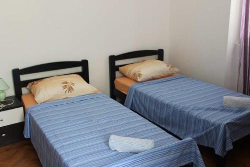 two beds sitting next to each other in a room at The Sea House Jaz in Preko