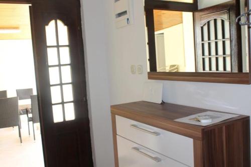 a bathroom with a wooden dresser and a mirror at The Sea House Jaz in Preko