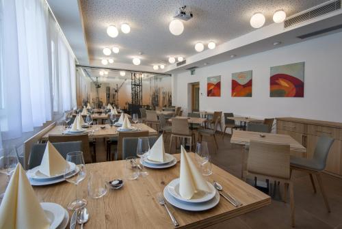 una sala da pranzo con tavoli e sedie in legno di HOTEL A RESTAURACE U STAVAŘE a Vsetín