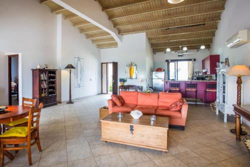 a living room with a couch and a table at Cozy Bungalow in the Tropical Gardens of Blue Bay in Blue Bay