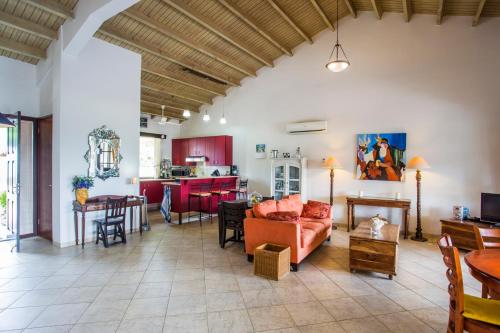 a living room with a couch and a table at Cozy Bungalow in the Tropical Gardens of Blue Bay in Blue Bay