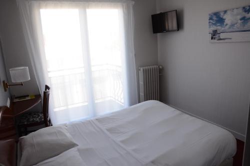 een slaapkamer met een wit bed en een raam bij Logis Le Petit Trianon in Saint-Brevin-les-Pins