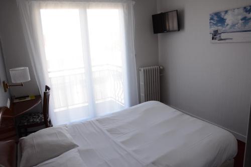 a bedroom with a white bed and a window at Logis Le Petit Trianon in Saint-Brevin-les-Pins