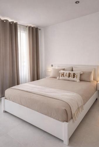 a white bedroom with a large white bed in a room at Maison prairie en fleurs in Le Perray-en-Yvelines