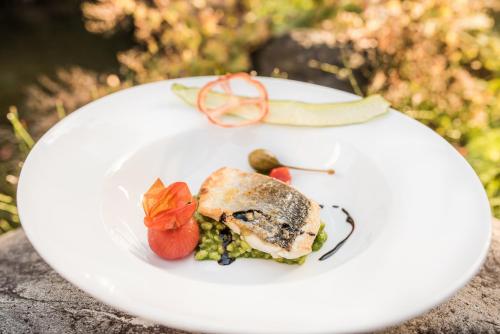 a white plate with food on a table at Hotel Braunsbergerhof in Lana