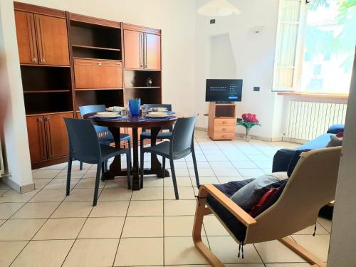 a living room with a table and chairs and a television at La Finestra sui Tigli in Mandello del Lario