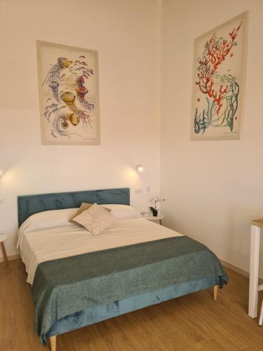a bedroom with a bed with two pictures on the wall at Antò 2.0 in Castellammare del Golfo