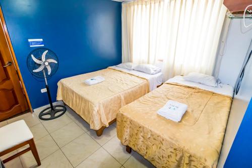 ein Zimmer mit zwei Betten und einem Ventilator in der Unterkunft Hotel JORGE CHAVEZ in Trujillo