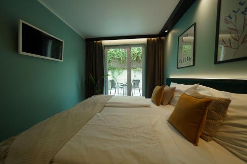 a large bed in a room with a window at Hotel BEE GREEN Schönbrunn in Vienna
