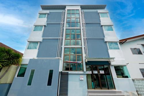 a tall white building with glass windows at RQ Suvarnabhumi Airport by Collection O in Bangkok