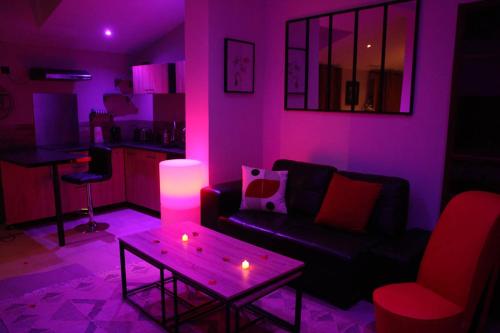 a living room with a couch and a table with candles at Secret Balnéo in Floirac