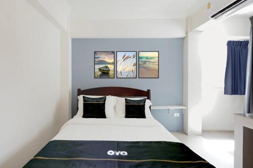 a bedroom with a large bed with two paintings on the wall at Dancenter Rq Suvarnabhumi Airport in Bangkok