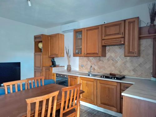 a kitchen with wooden cabinets and a table and chairs at Pintadera in San Giovanni