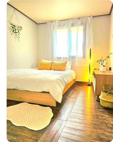 a bedroom with a large bed and a window at k조이스테이 in Pongsan-dong