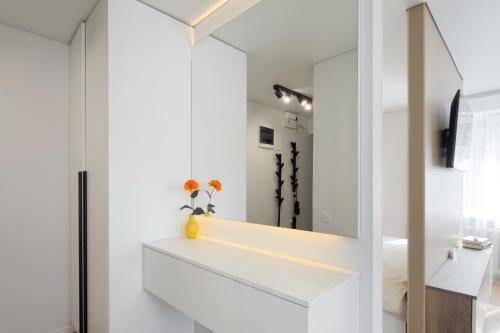 a bathroom with white walls and a mirror at AC Vienibas Square apartments in Daugavpils
